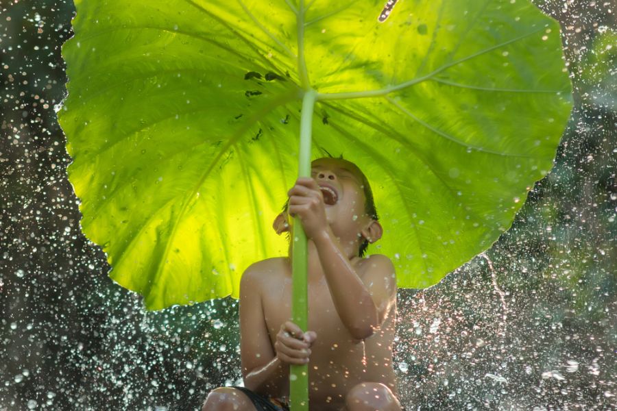 Jongentje in de regen in Thailand